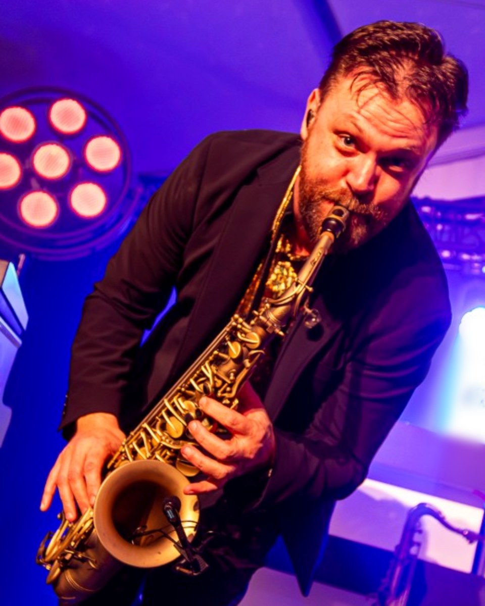 De saxofonist tussen de gasten