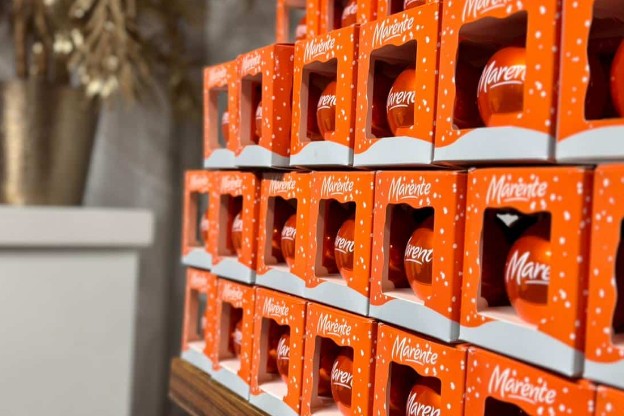 Gestapelde oranje dozen met een Marente-kerstbal
