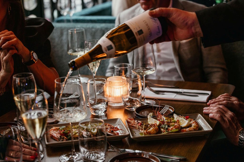 Er wordt bubbels ingeschonken aan een gedekte brunchtafel