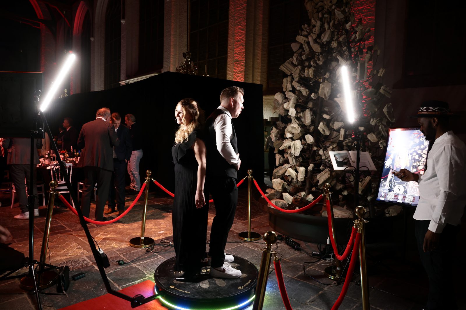 Twee gasten staan op de 360° spinning booth in een ruimte met lichtstatieven