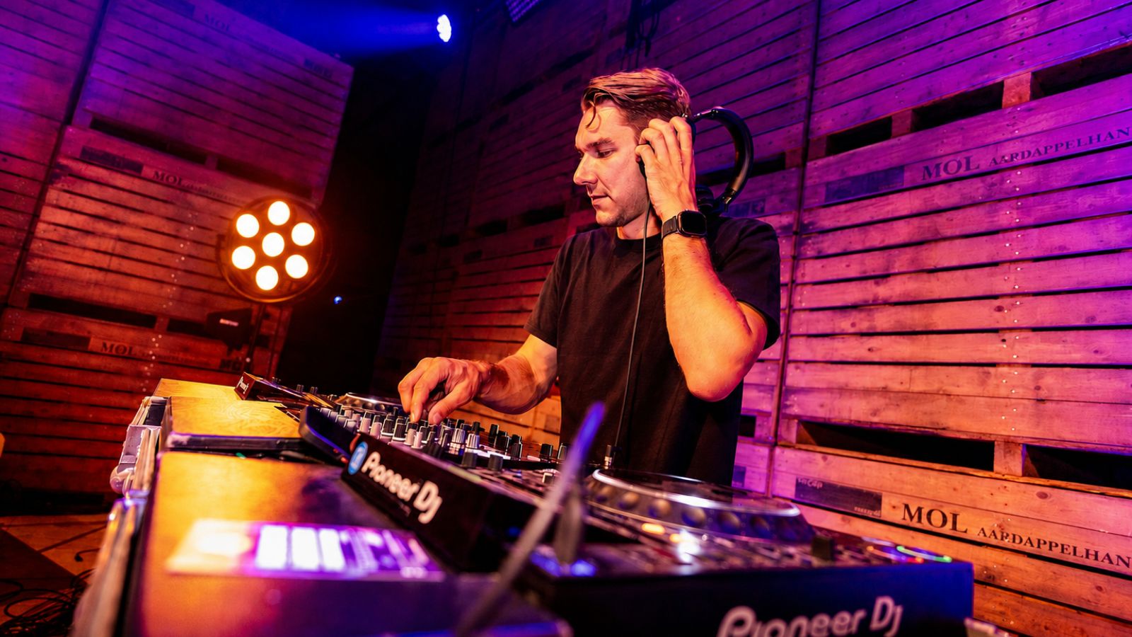 Een DJ draait achter zijn set tijdens een bedrijfsfeest