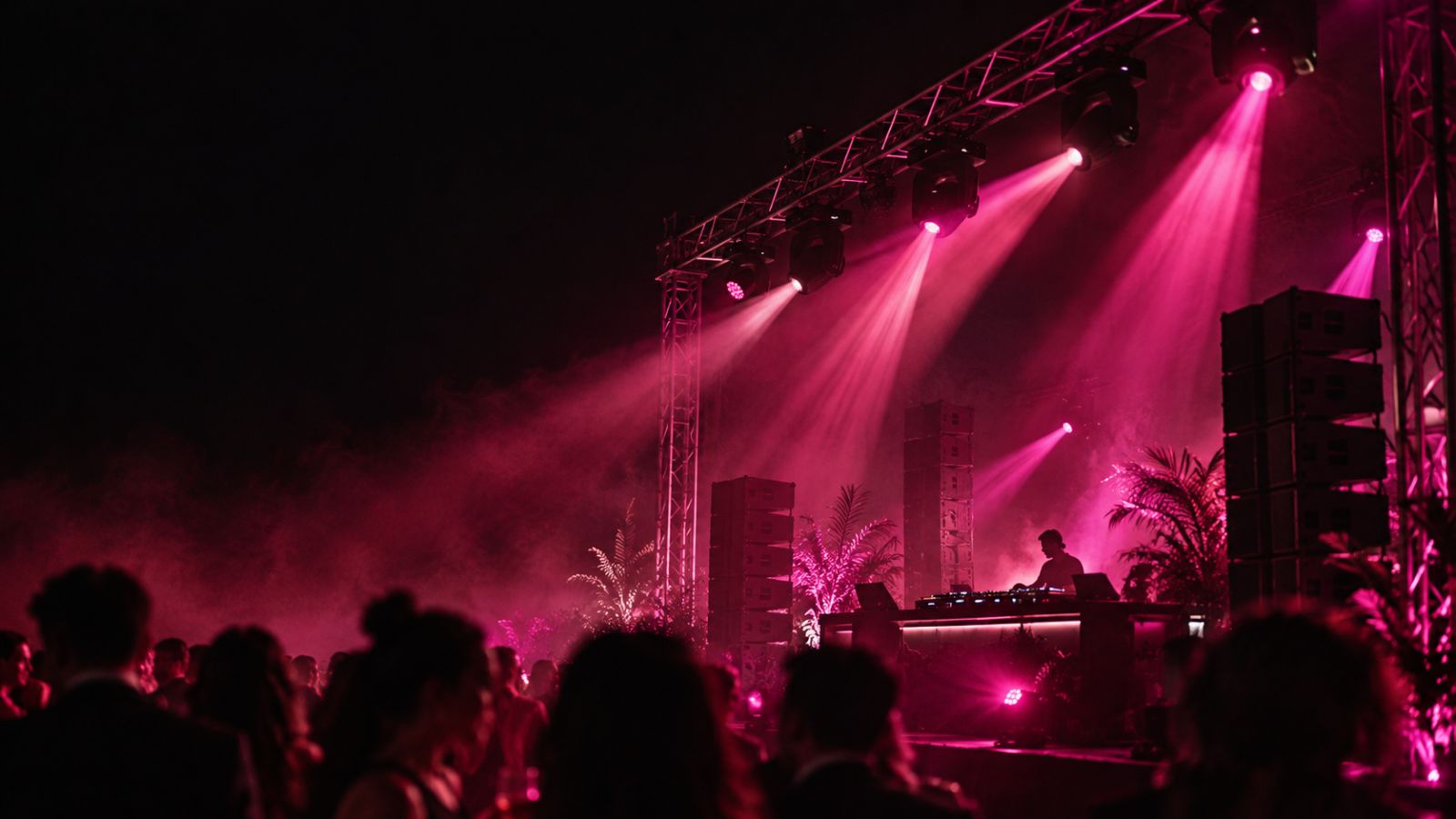 Podium met truss, moving heads en speakers in roze licht tijdens een avondevenement